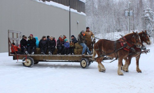 Large Group of children and adults on carriage being pulled by two horses